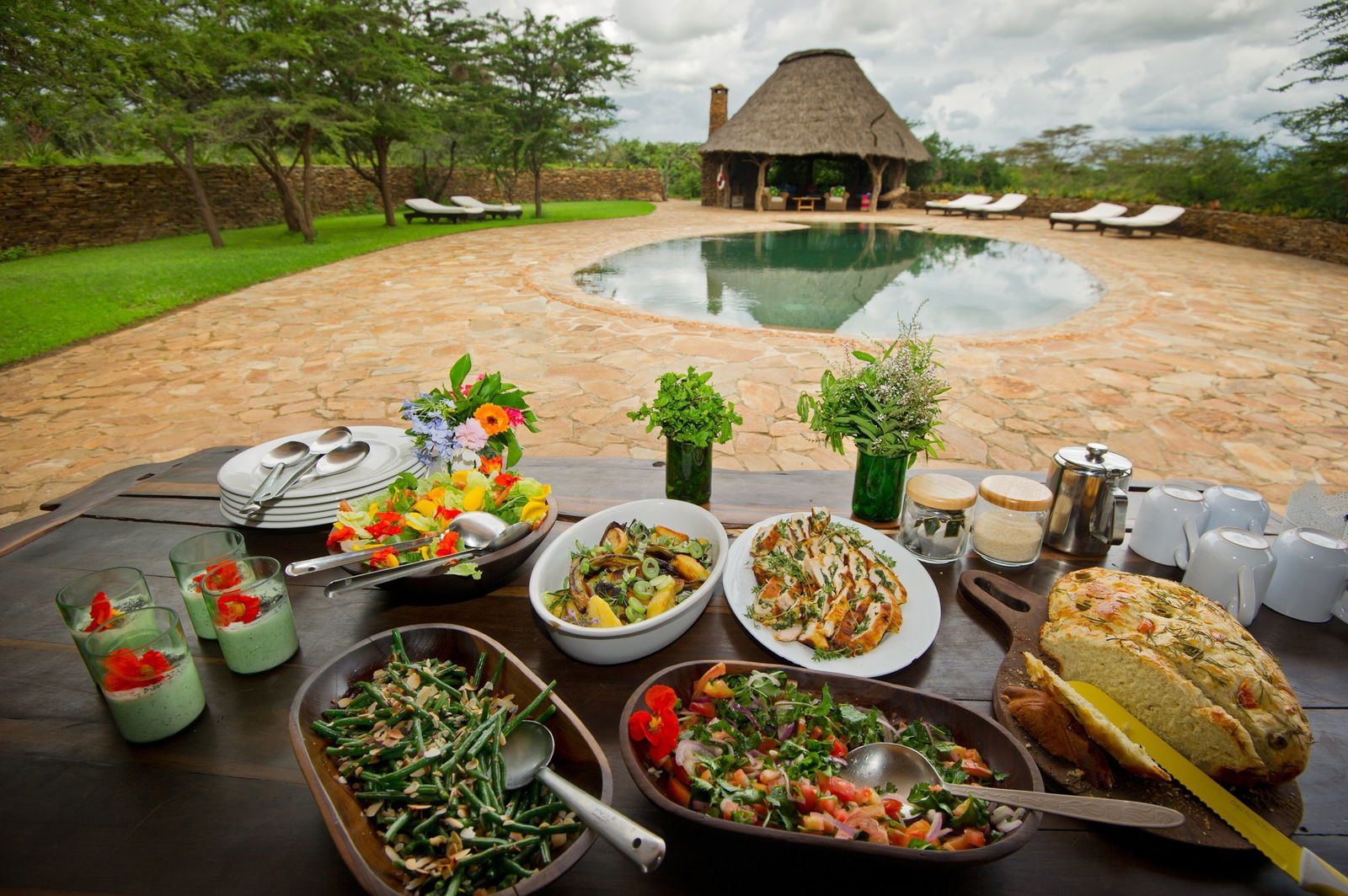 Dining setup by the pool at El Karama Lodge