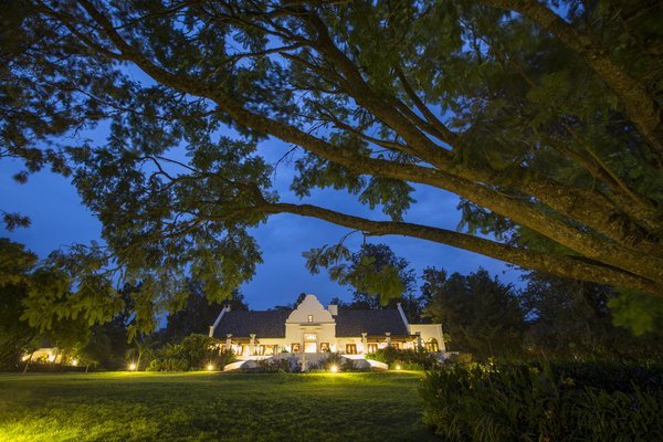 Exterior view of the Manor at Ngorongoro during the night with its expansive lawn