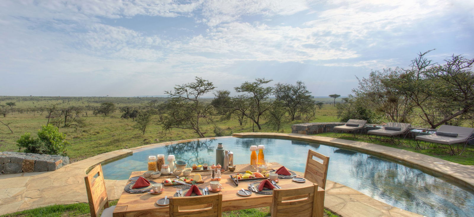 Outside dining set up next to the pool with views of Mara at Naboisho Camp