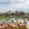 Outside dining set up next to the pool with views of Mara at Naboisho Camp