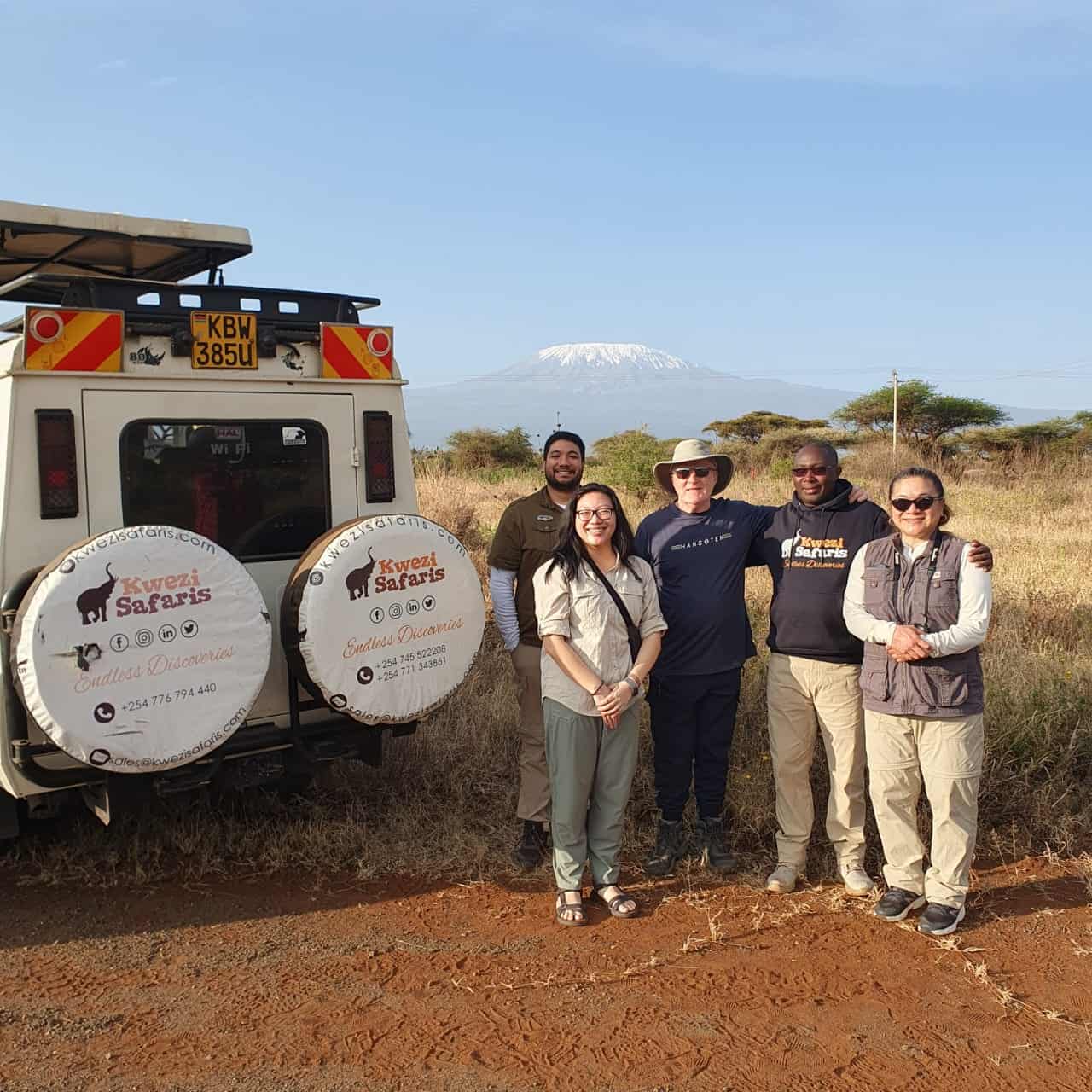 Tourists taking a picture while on a 6-day Kenya Wildlife safari with Mount Kilimanjaro as backdrop
