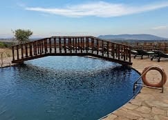 A Serene swimming pool glisters under a clear blue sky in Lobo Wildlife Lodge in Tanzania